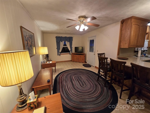 living room with ceiling fan and ornamental molding