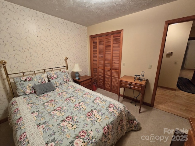 bedroom featuring a textured ceiling, a closet, and light hardwood / wood-style floors