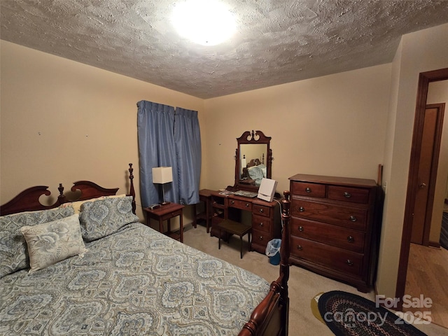 bedroom with light carpet and a textured ceiling