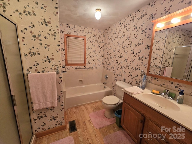 bathroom with toilet, vanity, a washtub, and hardwood / wood-style floors