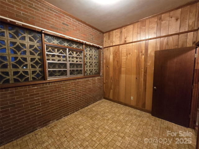 wine cellar with brick wall, ornamental molding, and wooden walls