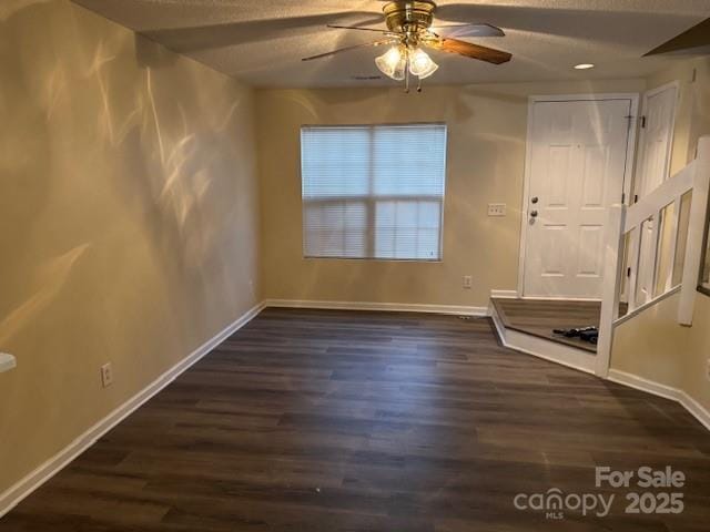 interior space featuring ceiling fan, a textured ceiling, and dark hardwood / wood-style flooring