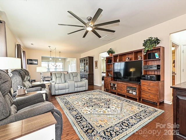 living room featuring dark hardwood / wood-style flooring and ceiling fan with notable chandelier