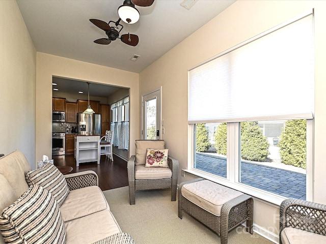 living room with ceiling fan, wood finished floors, and visible vents