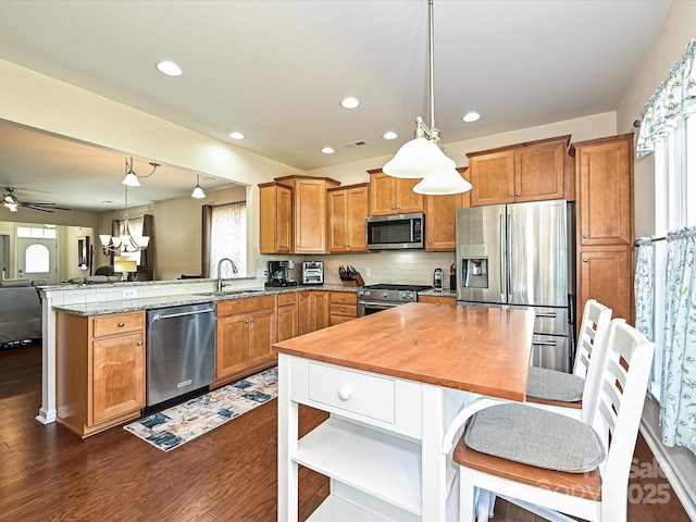 8024 Carolina Lakes Way, Fort Mill, SC 29707 - kitchen with appliances with stainless steel finishes, a sink, a peninsula, brown cabinets, and open floor plan