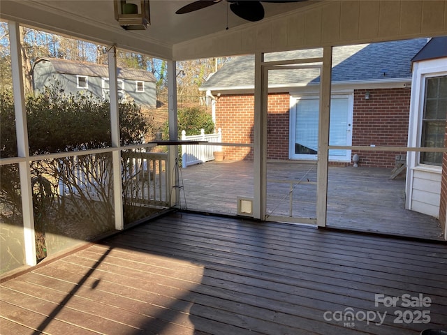 unfurnished sunroom featuring ceiling fan