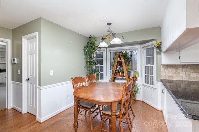 dining area featuring light wood-style flooring and baseboards