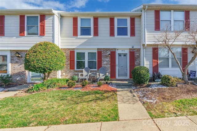 townhome / multi-family property featuring a front lawn