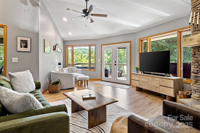 living room featuring ceiling fan, a healthy amount of sunlight, lofted ceiling, and light hardwood / wood-style flooring