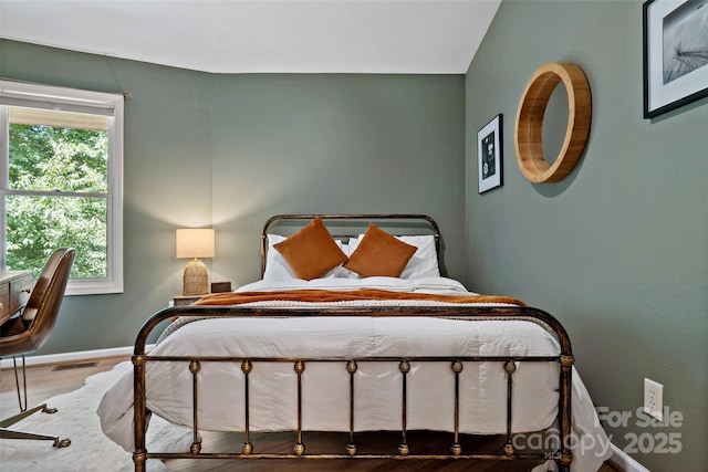 bedroom with wood-type flooring and multiple windows