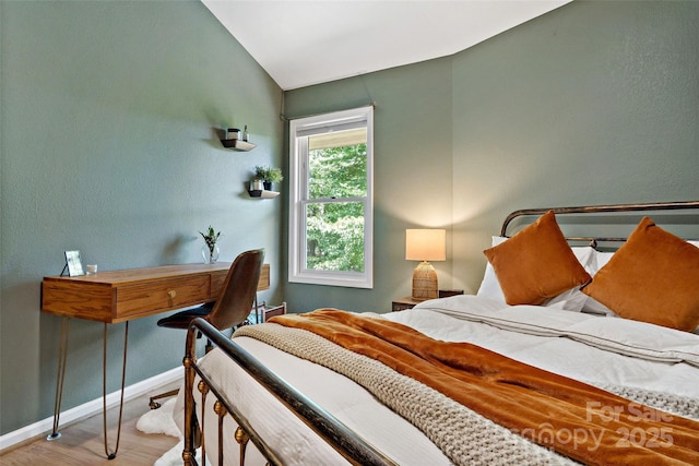 bedroom featuring light hardwood / wood-style floors and lofted ceiling