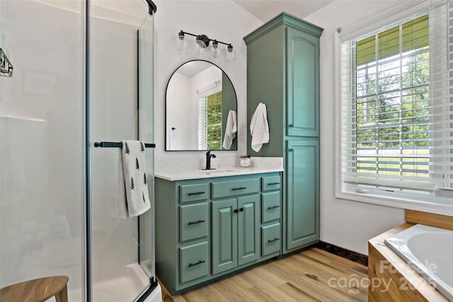 bathroom with hardwood / wood-style floors, vanity, and independent shower and bath