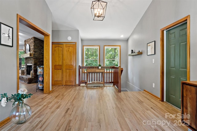 entryway featuring a fireplace, light hardwood / wood-style flooring, and a notable chandelier