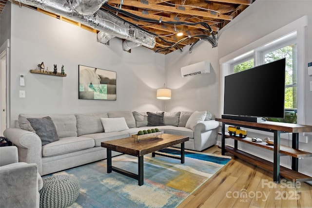 living room featuring beamed ceiling, hardwood / wood-style flooring, and a wall mounted air conditioner