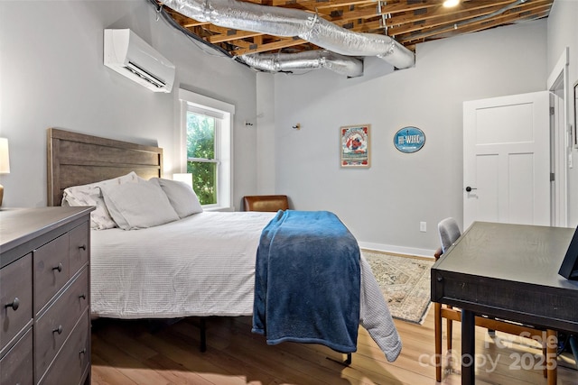 bedroom featuring an AC wall unit and hardwood / wood-style floors