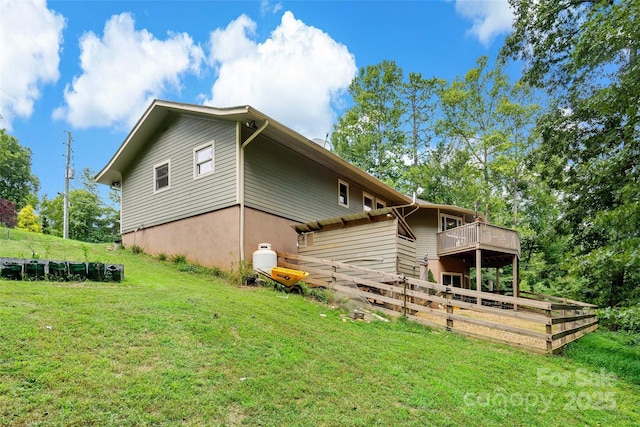 view of home's exterior with a deck and a lawn