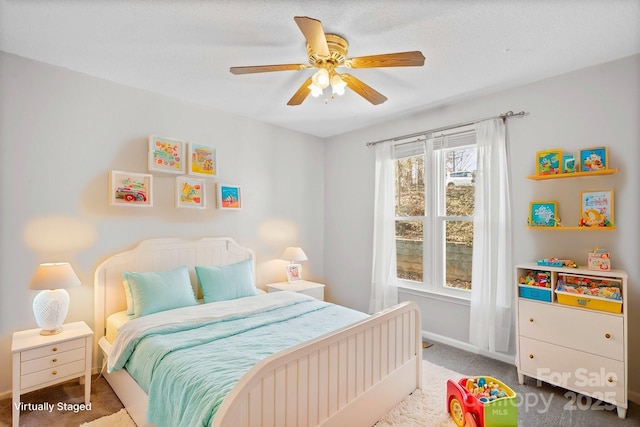 bedroom with ceiling fan, carpet floors, and a textured ceiling