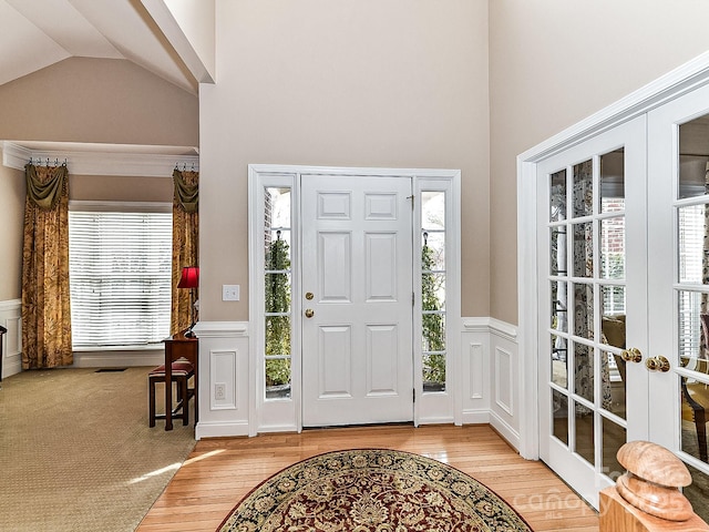 entrance foyer with french doors, lofted ceiling, light wood-type flooring, and a wealth of natural light