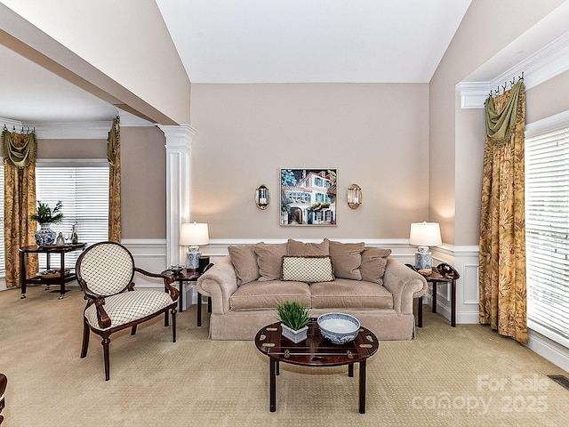 living room with decorative columns, lofted ceiling, and light carpet