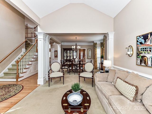 living room with ornate columns, lofted ceiling, a chandelier, hardwood / wood-style flooring, and ornamental molding