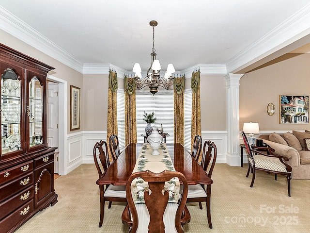 carpeted dining area with a notable chandelier, crown molding, and ornate columns