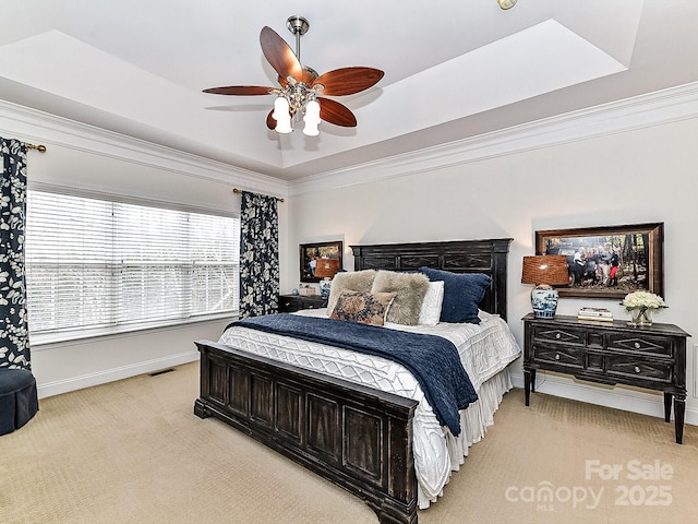 bedroom with crown molding, ceiling fan, a tray ceiling, and light carpet