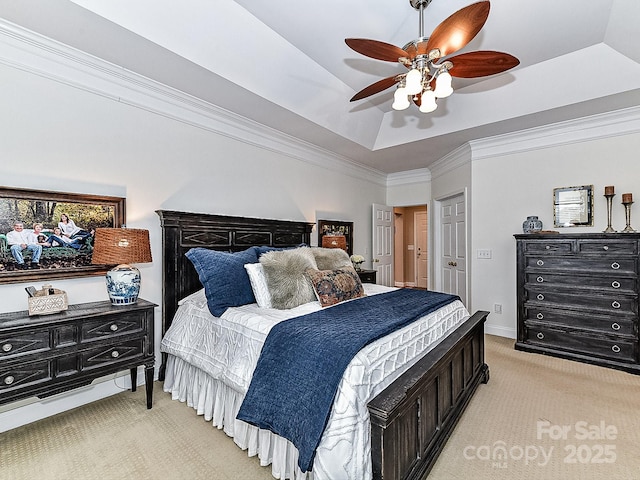 bedroom with ceiling fan, ornamental molding, a tray ceiling, and light carpet