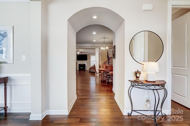 corridor with dark wood-type flooring and ornamental molding