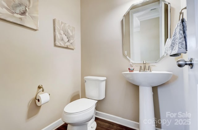 bathroom featuring hardwood / wood-style flooring and toilet