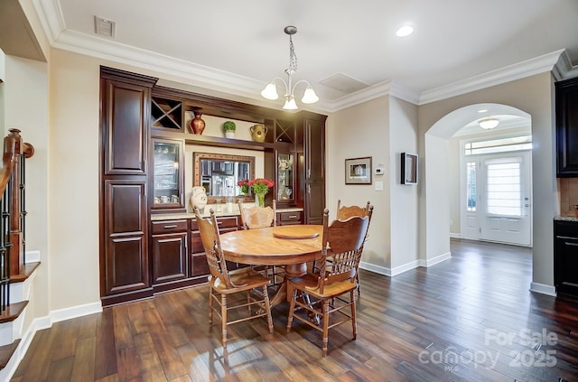 dining area featuring an inviting chandelier, ornamental molding, and dark hardwood / wood-style flooring