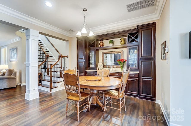 dining space with decorative columns, ornamental molding, and dark hardwood / wood-style flooring