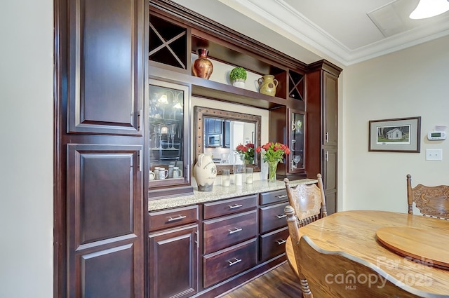 bar featuring dark hardwood / wood-style flooring, light stone countertops, and ornamental molding