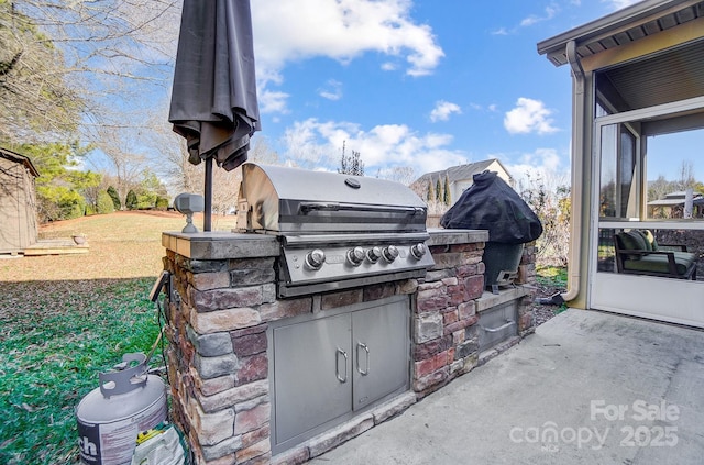 view of patio featuring an outdoor kitchen and a grill