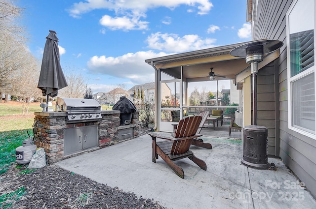 view of patio / terrace featuring ceiling fan, an outdoor kitchen, and a grill