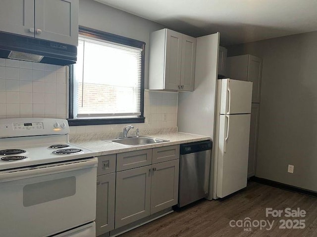 kitchen with tasteful backsplash, white appliances, dark hardwood / wood-style flooring, and sink