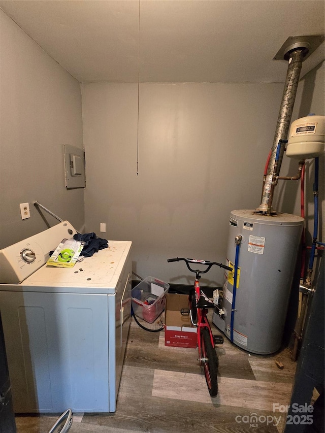 clothes washing area featuring hardwood / wood-style floors, washer / dryer, and gas water heater