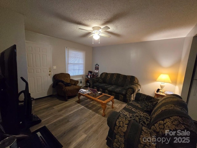 living room featuring hardwood / wood-style floors, a textured ceiling, and ceiling fan