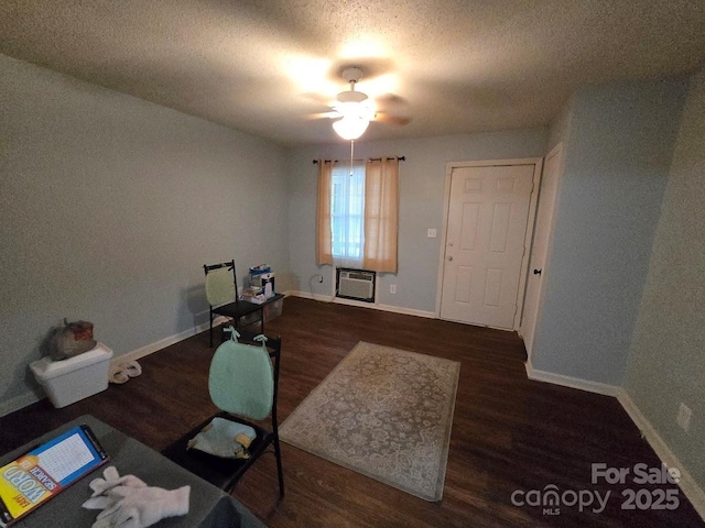 unfurnished office featuring ceiling fan, a textured ceiling, dark wood-type flooring, and a wall mounted AC