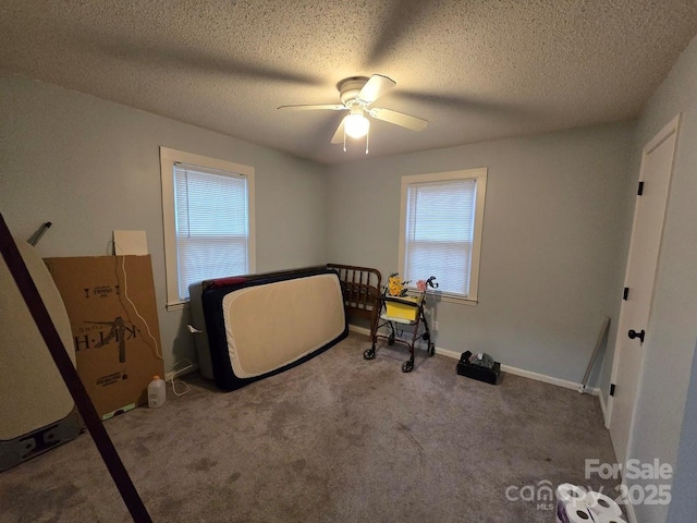 bedroom featuring ceiling fan, carpet, and a textured ceiling