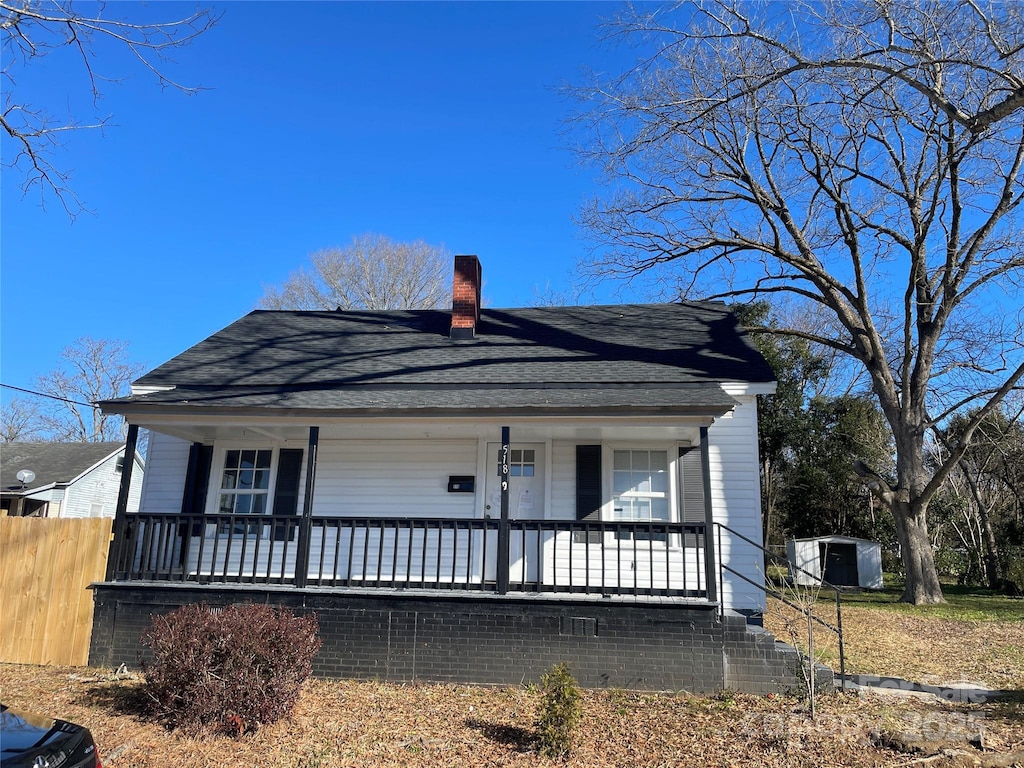 view of front of house with a shed and a porch