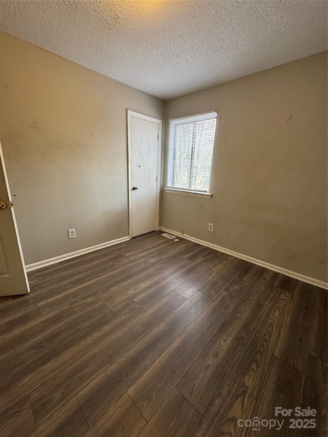 unfurnished bedroom featuring dark wood-type flooring and a textured ceiling