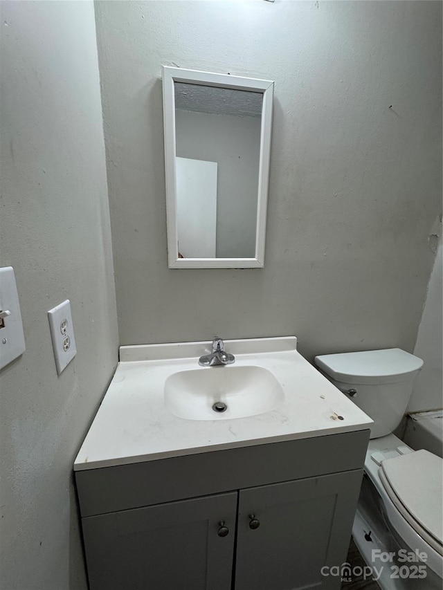 bathroom featuring toilet and vanity