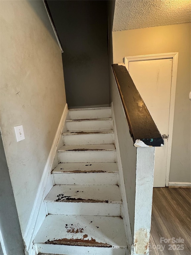 stairway with a textured ceiling