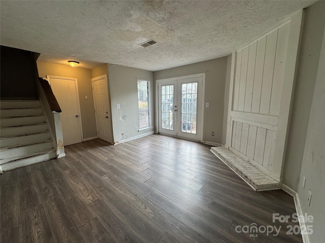 interior space featuring french doors, dark wood-type flooring, and a textured ceiling