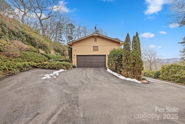 view of home's exterior with a mountain view and a garage