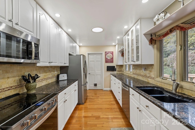 kitchen featuring sink, dark stone counters, white cabinets, and appliances with stainless steel finishes