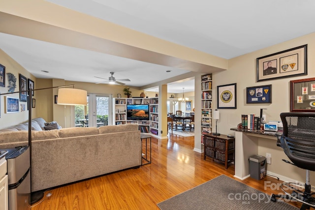 living room featuring hardwood / wood-style flooring and ceiling fan with notable chandelier