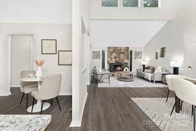 10912 Treebark Dr, Charlotte, NC 28226 - living area with wood finished floors, a high ceiling, baseboards, and a stone fireplace