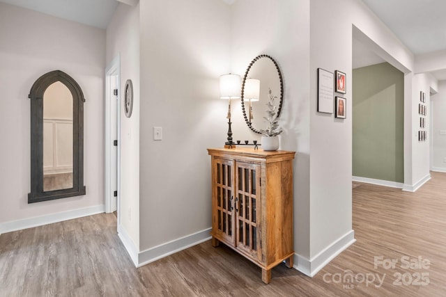 hall with baseboards and wood finished floors