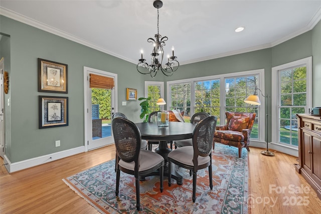 dining area featuring light hardwood / wood-style floors, an inviting chandelier, and ornamental molding